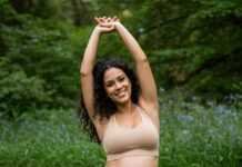 The Best Pregnancy Exercises for Each Trimester Pregnant woman stretching in park.