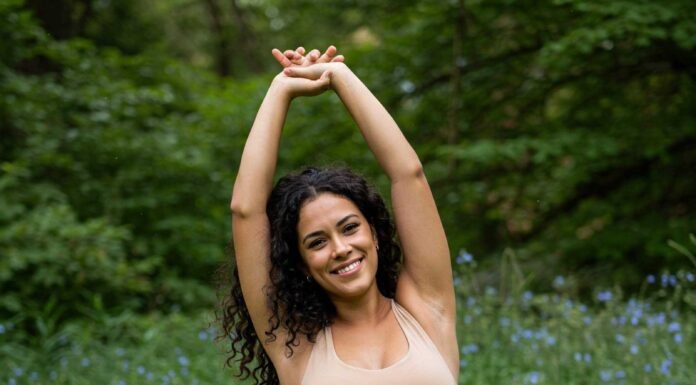 The Best Pregnancy Exercises for Each Trimester Pregnant woman stretching in park.